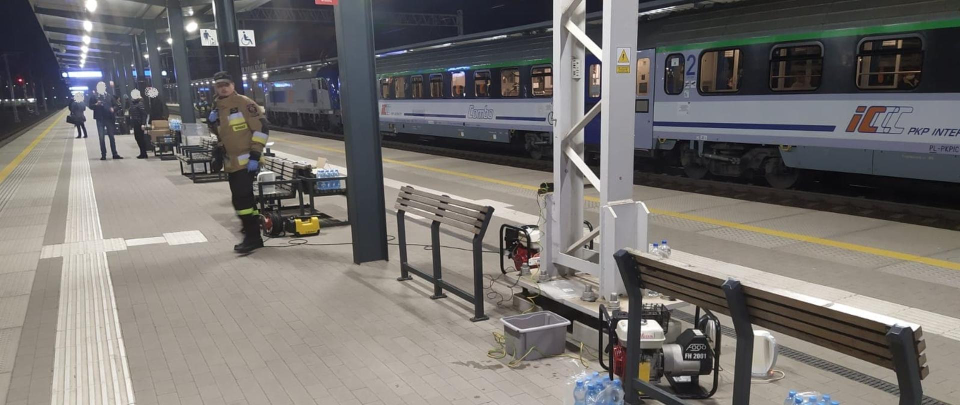 Zdjęcie przedstawia peron dworca PKP w Koninie. Na peronie strażacy dostarczyli wodę i żywność dla uchodźców z Ukrainy, którzy podróżują pociągiem. 
