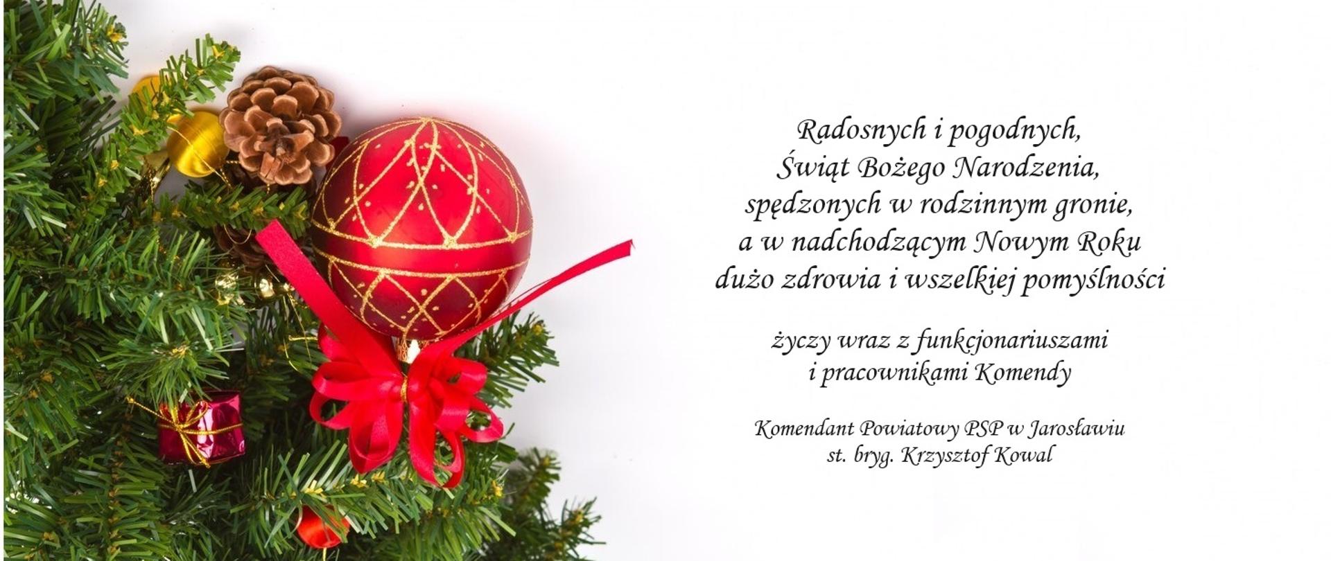 Po lewej stroik choinkowy z bombką i ozdobami. Po prawej życzenia "Radosnych i pogodnych Świąt Bożego Narodzenia, spędzonych w rodzinnym gronie, a w nadchodzącym Nowym Roku dużo zdrowia i wszelkiej pomyślności życzy wraz z funkcjonariuszami i pracownikami Komendy Komendant Powiatowy PSP w Jarosławiu st. bryg. Krzysztof Kowal".