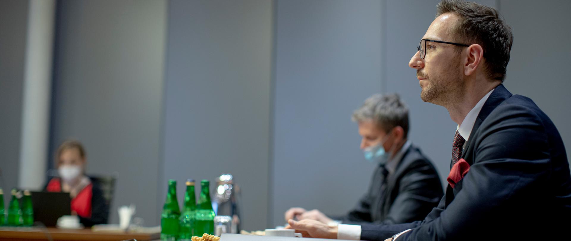 W sali przy stole siedzą trzy osoby. Na pierwszym planie wiceminister Waldemar Buda.