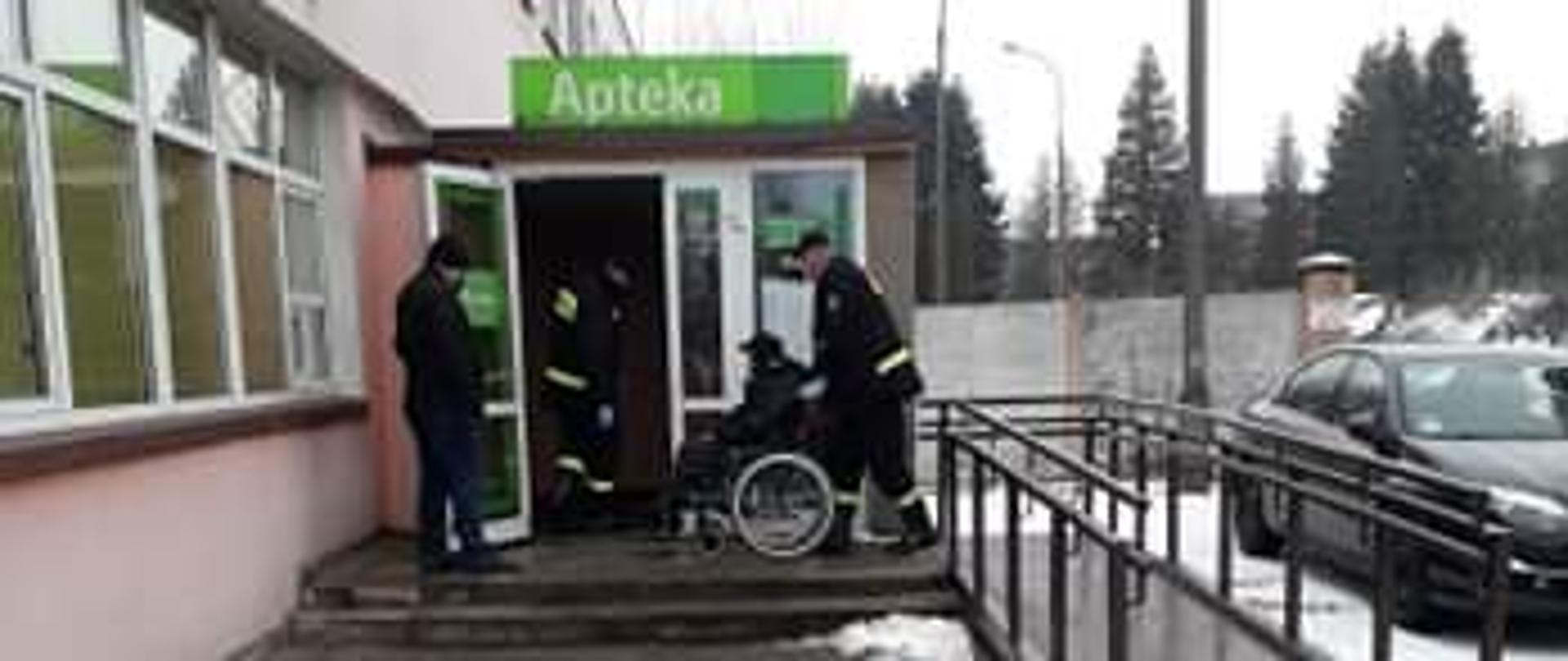 Na zdjęciu transport osoby starszej na wózku do przychodni celem wykonania szczepienia