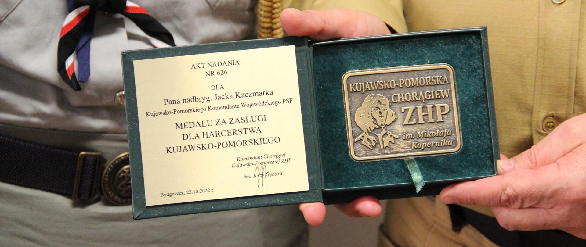 Widok na medal, trzymany w ręku.