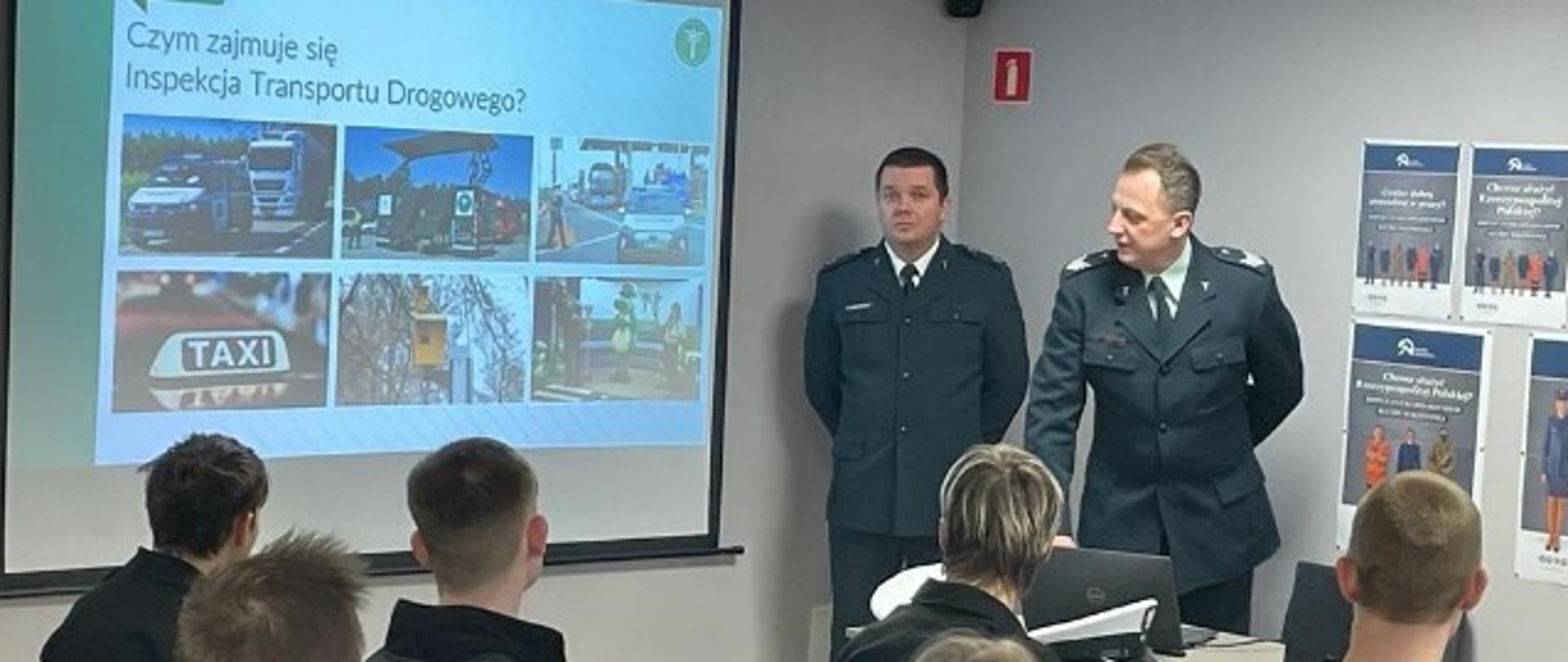 Uczniowie odwróceni w kierunku dwóch Inspektorów prowadzących prezentację