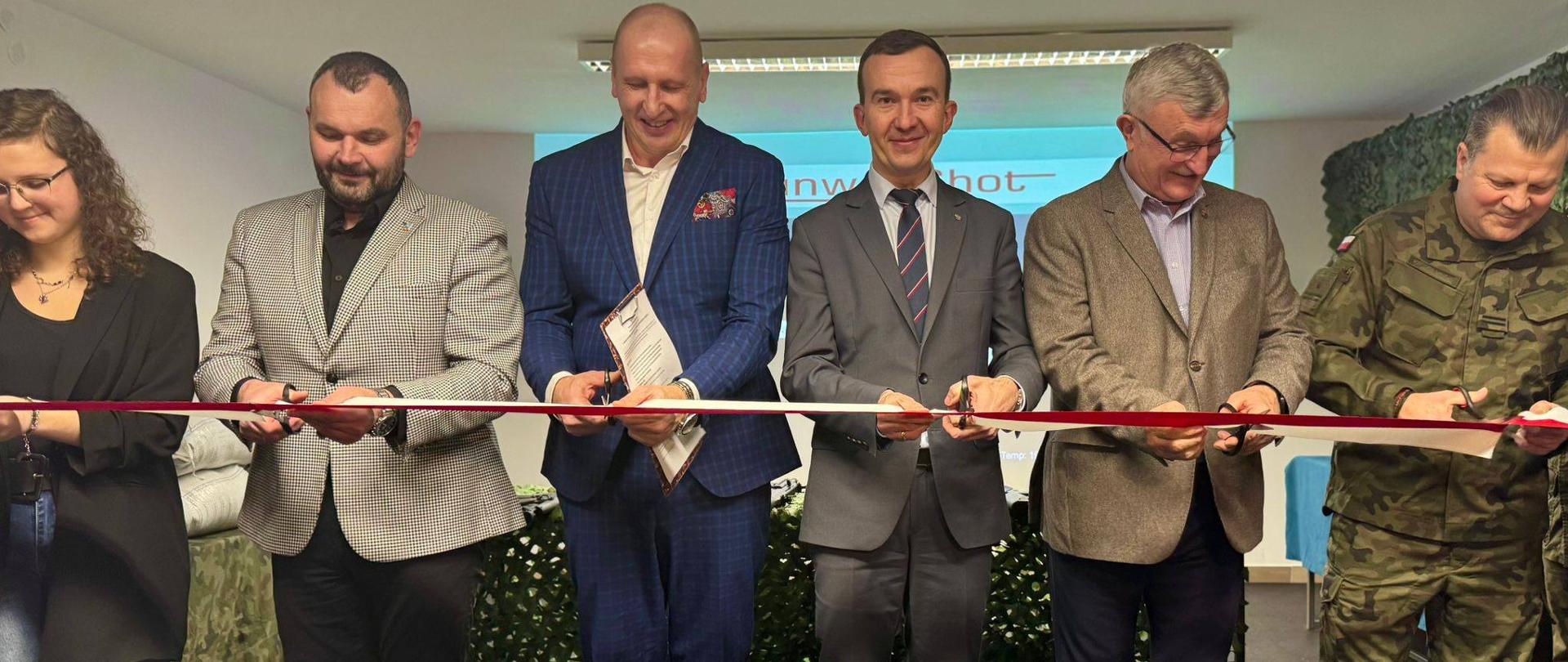 6 osób stoi przy biało-czerwonej szarfie, którą oficjalnie przecinają 