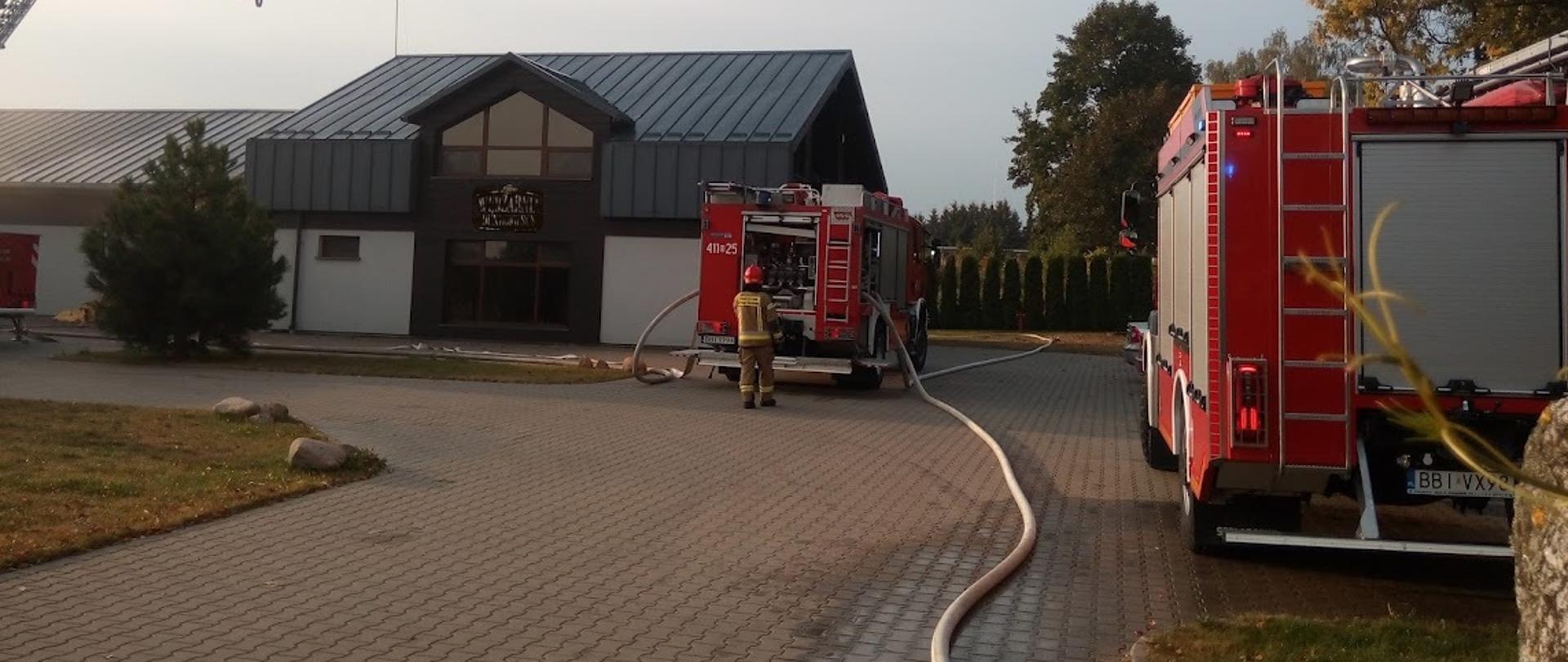 Zdjęcie przedstawia akcje gaszenia budynku produkcyjnego, w te wozy ratowniczo gaśnicze 