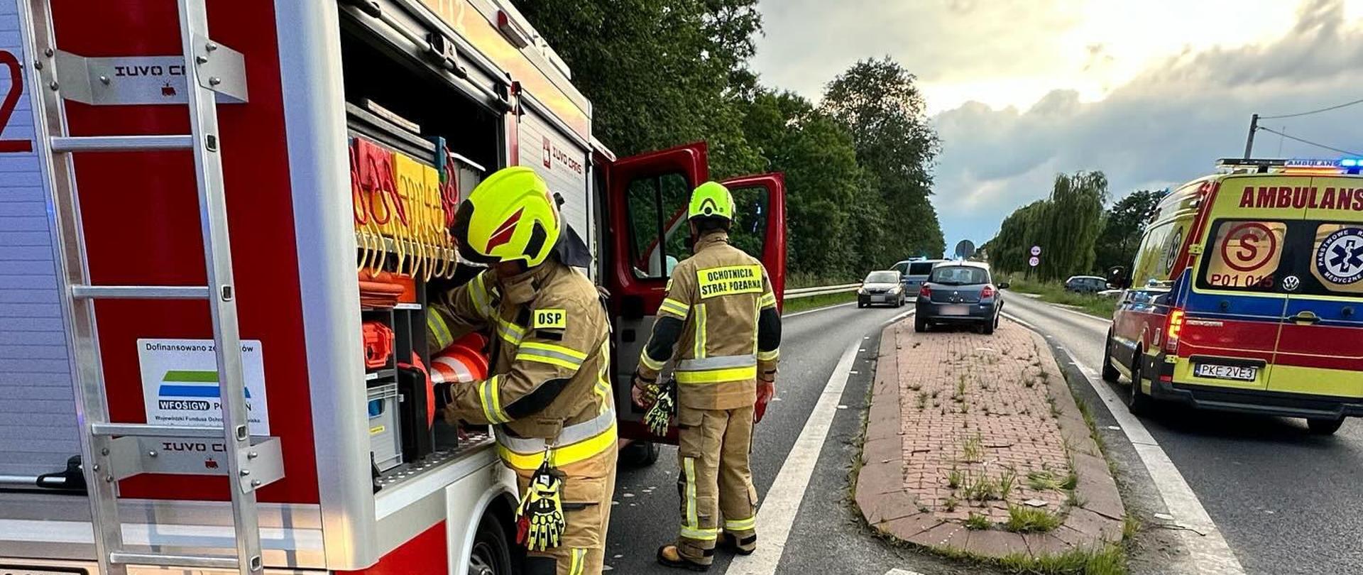Widoczne miejsce zdarzenia uszkodzony pojazd oraz służby podczas działań.
