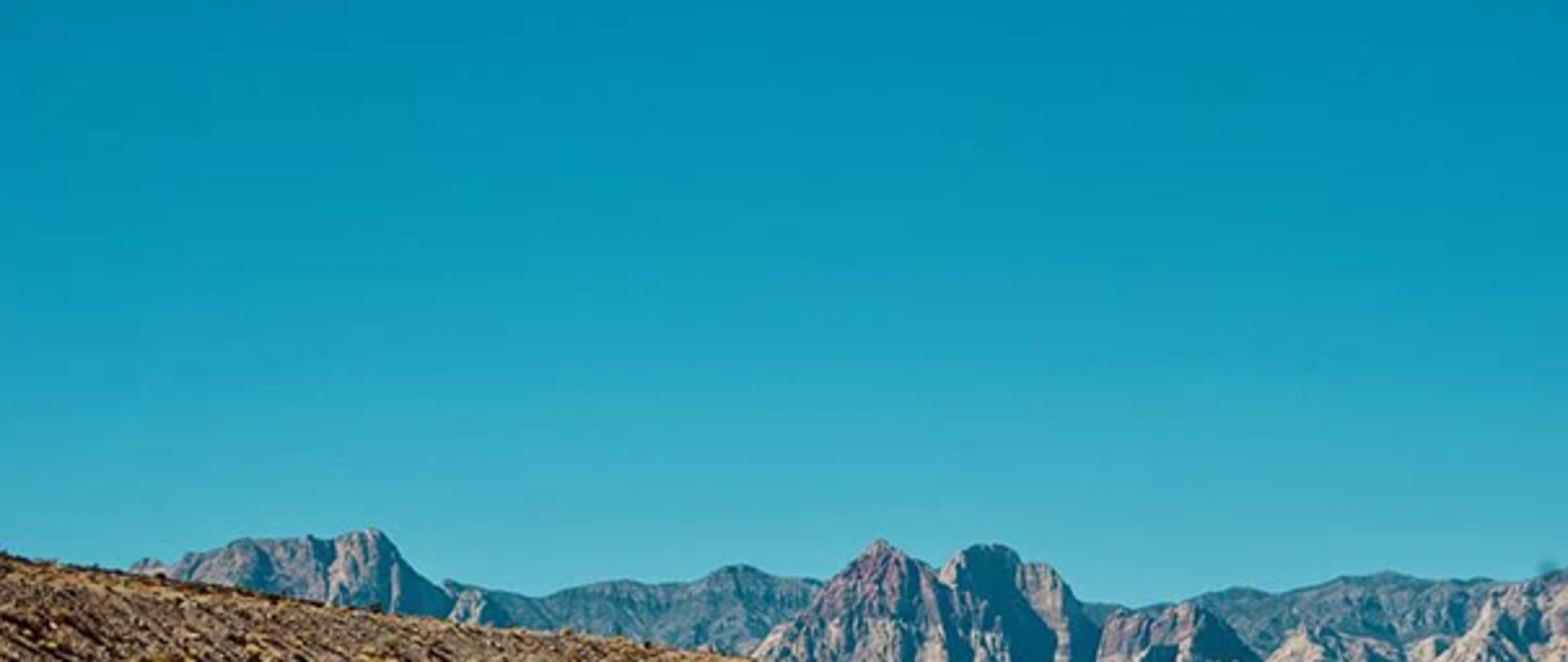 Droga asfaltowa z pomarańczowym samochodem na prawym pasie.