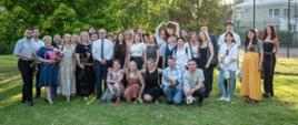 Zdjęcie grupowe słuchaczy, nauczycieli i absolwentów Studium. Wszyscy stoją na trawie, obok siebie i pozują na tle drzew. 