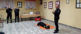 Spotkanie z mieszkańcami. Funkcjonariusz KP PSP w Oleśnie przeprowadza instruktaż udzielania pierwszej pomocy.