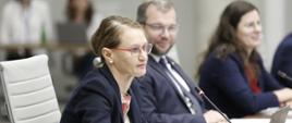 Obrady Rady Wykonawczej ds. wdrażania Krajowej Polityki Miejskiej 2030, na pierwszym planie siedząca przy stole dyrektor Departamentu Strategii MFiPR Renata Calak, po prawej od dyrektor siedzi minister funduszy i polityki regionalnej Grzegorz Puda