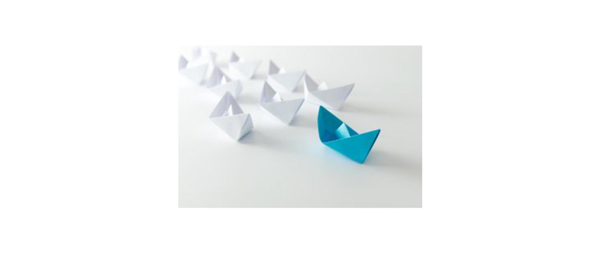 Na zdjęciu: łódki złożone z papieru stojące w rzędach