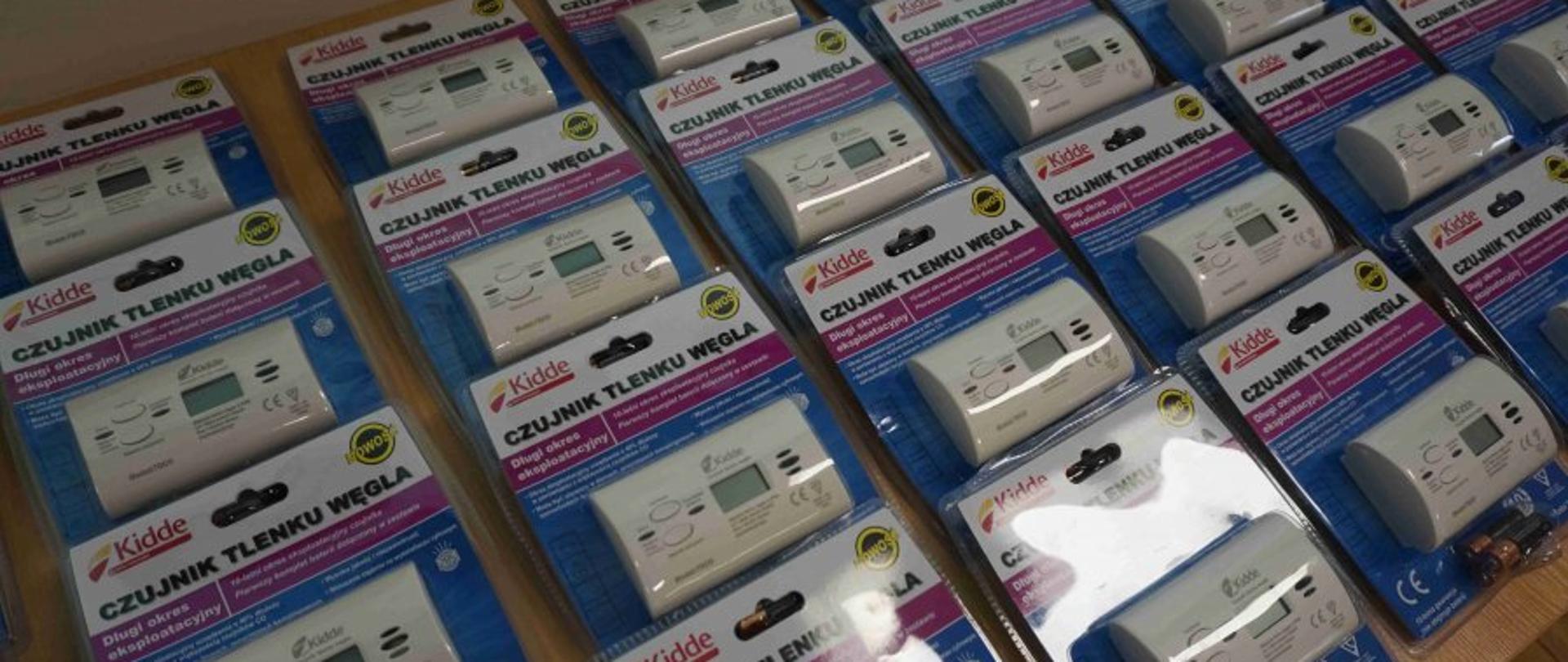 Na stole leżą czujniki tlenku węgla, które zostaną wręczone mieszkańcom powiatu krotoszyńskiego. 