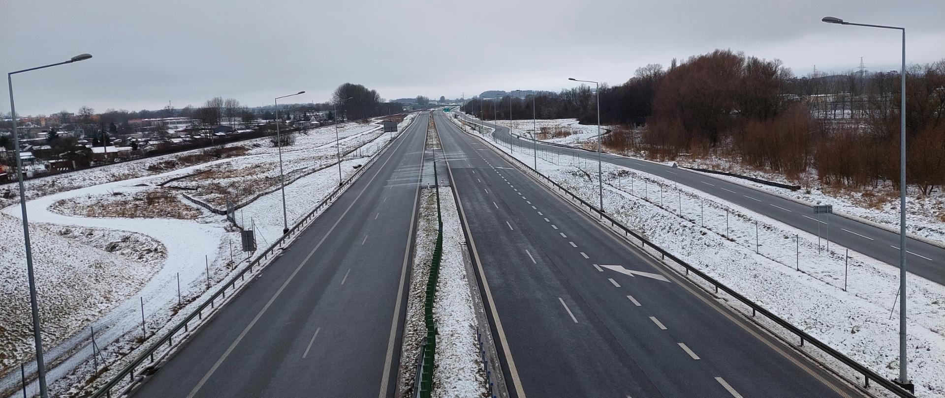 Droga ekspresowa S11 w scenerii zimowej. Dwujezdniowa droga ekspresowa po dwa pasy ruchu w obu kierunkach będąca obwodnicą Szczecinka.