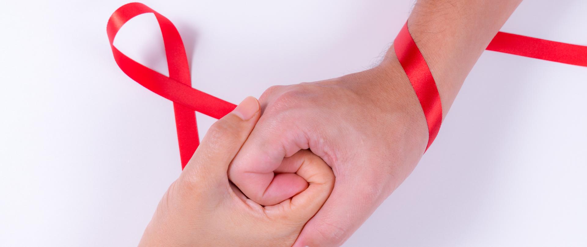 World AIDS Day. Man and woman holding hands with Red ribbon. Aids Awareness.