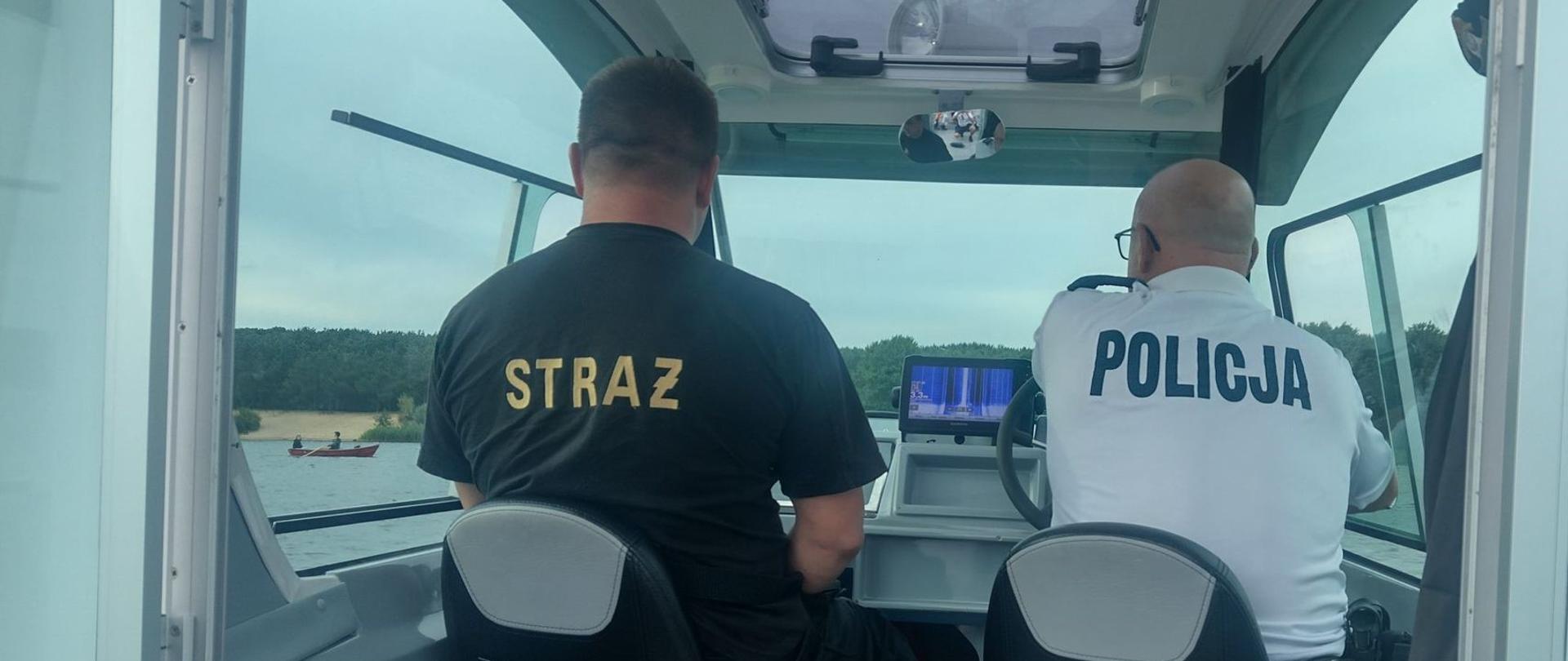 Na zdjęciu przedstawiono wnętrze łodzi patrolowej w której dwaj funkcjonariusze służb ratowniczych: straży pożarnej i Policji przeprowadzają patrol na akwenie w Cedzynie.