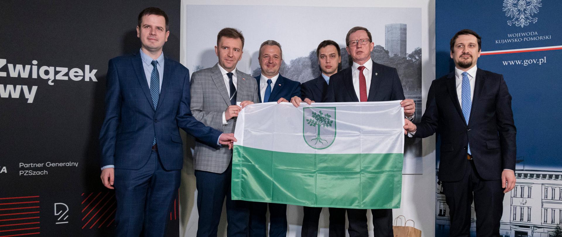 Sześciu mężczyzn trzymających flagę Kruszwicy