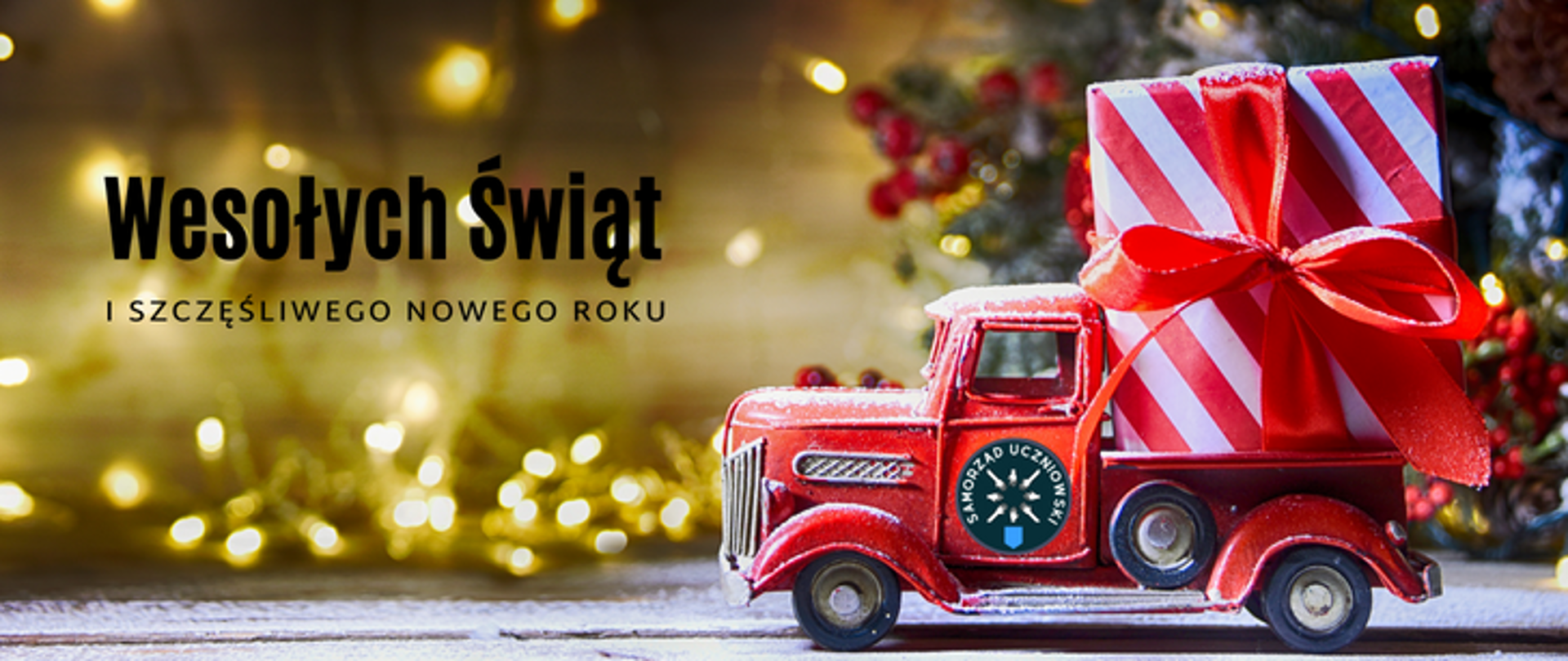 zdjęcie przedstawia kartkę świąteczną na złotym tle, po lewej stronie napis wesołych świąt i szczęśliwego nowego roku, po prawej ciężarówka świąteczna z prezentem oraz logotypem samorządu uczniowskiego
