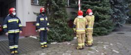 Strażacy wciągają flagę państwowa na maszt