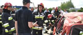 Instruktor instruujący strażaków jak bezpiecznie uwalniać poszkodowanych z pojazdu po wypadku 