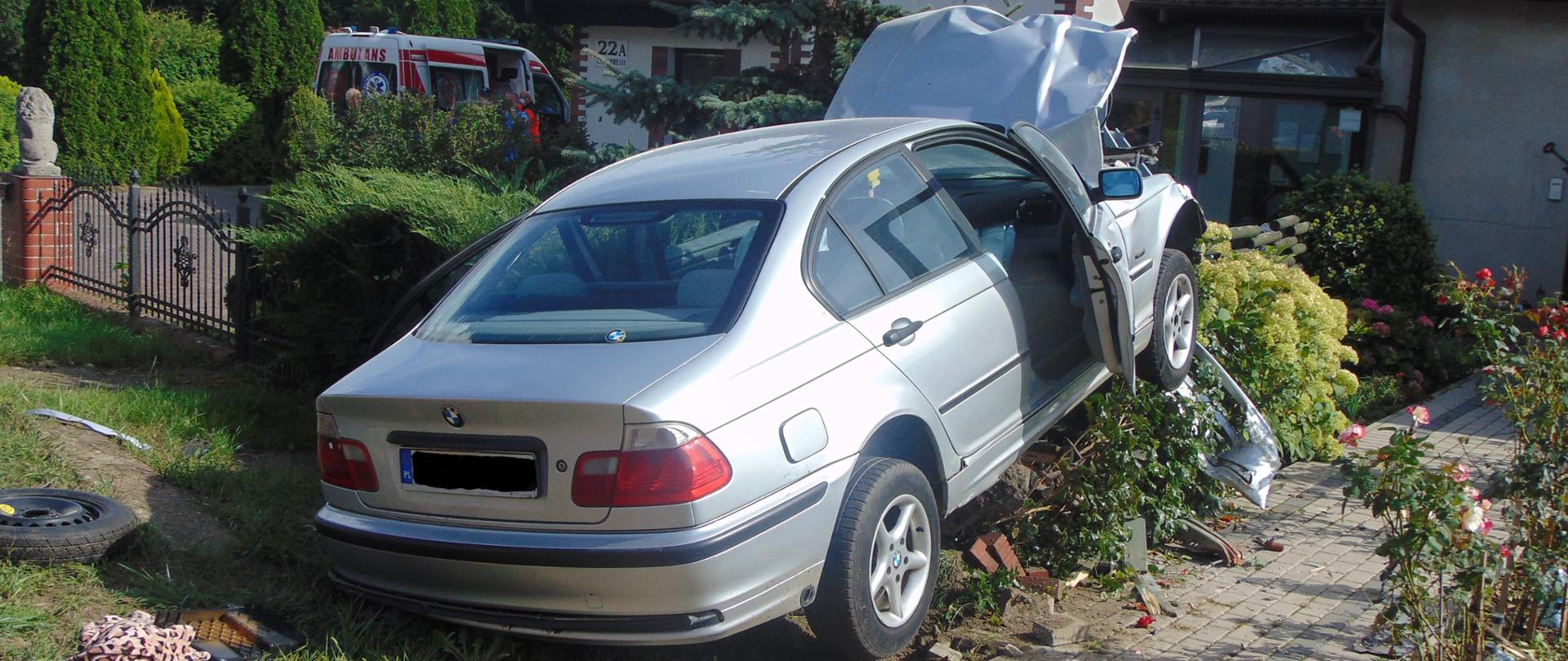 Auto osobowe uderzyło w ogrodzenia posesji i zawisło na murku betonowym.