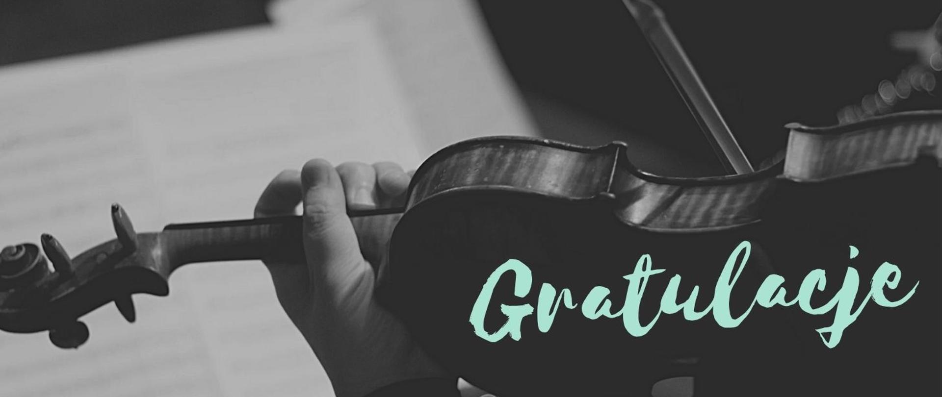 Tło obrazka w odcieniach czarno- białych. W tle grafika skrzypiec i smyczka, po lewej stronie biała rozmyta plama przypominająca kartki z nutami. Na skrzypcach w miętowym kolorze napis "skrzypce".