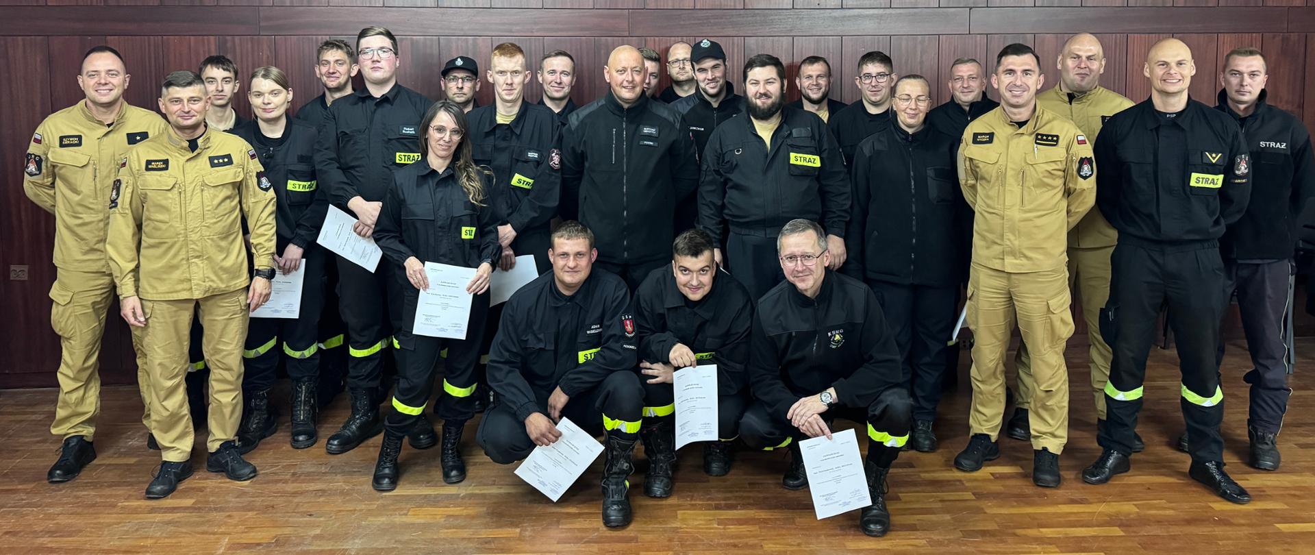 Uczestnicy kursu wraz z komisją stoją na wspólnym zdjęciu.