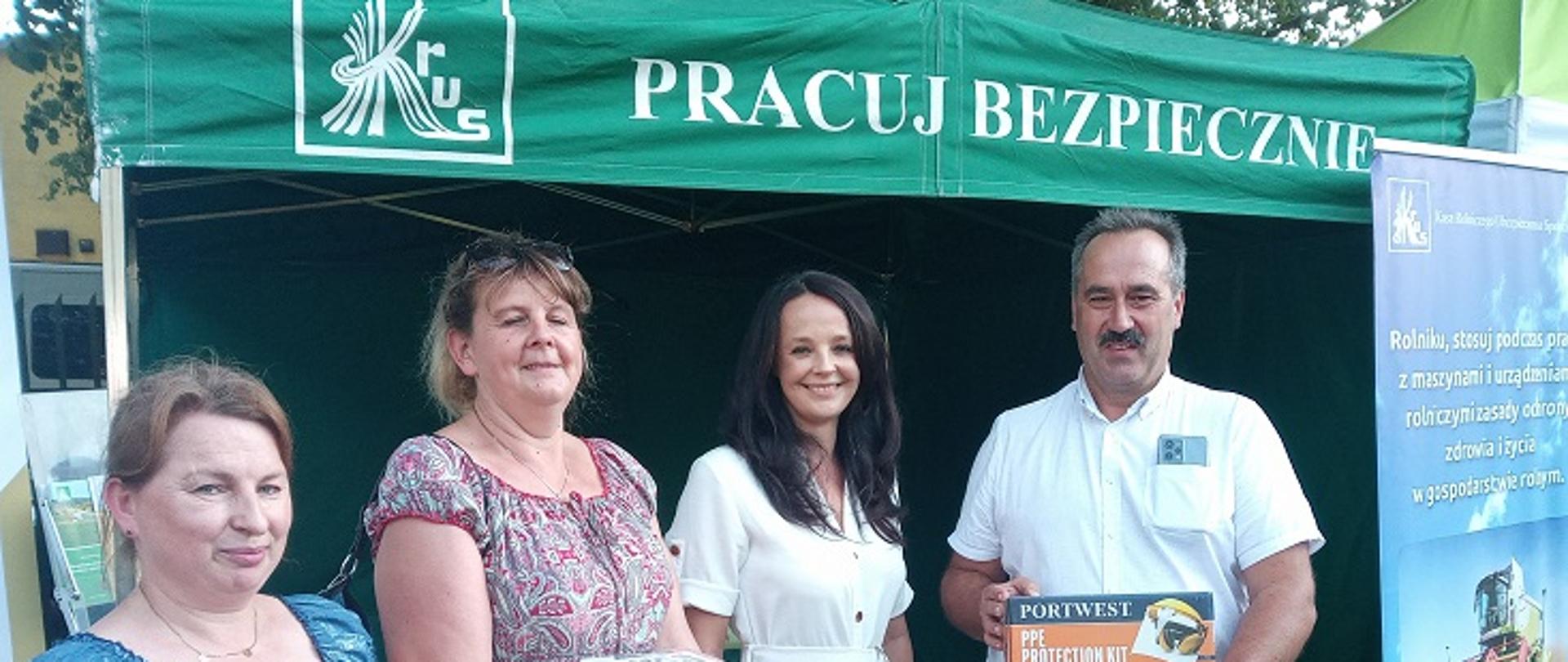 trzy kobiety i mężczyzna przy stoisku informacyjnym