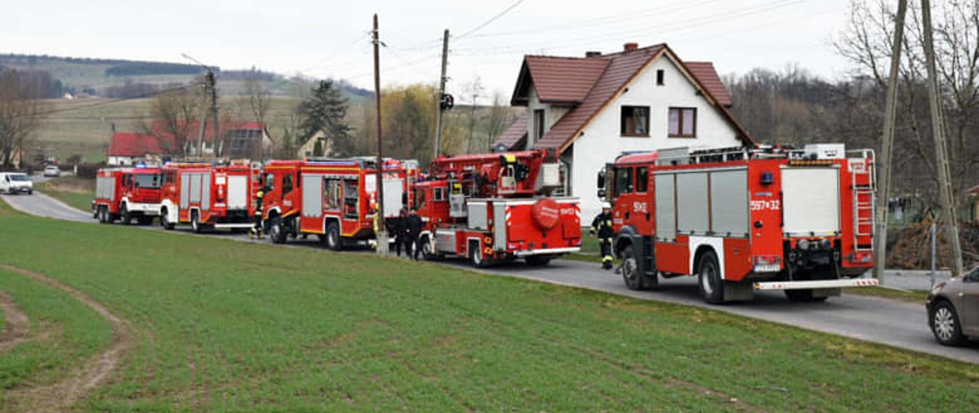 Wozy strażackie na drodze przy budynku w Lutomierzu