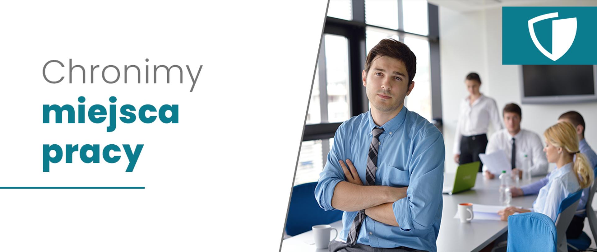 Grafika: po lewej stronie na białym tle napis: Chronimy miejsca pracy. Po prawej stronie zdjęcie ukazujące zespół w sali konferencyjnej. Na pierwszym planie młody mężczyzna w błękitnej koszuli i szarym krawacie, siedzi na brzegu stołu założonymi rękami. Za nim rozmazane pozostałe osoby z zespołu. Dwie kobiety i dwóch mężczyzn siedzących przy stole, na którym stoi woda, kubki i laptop oraz dokumenty. 