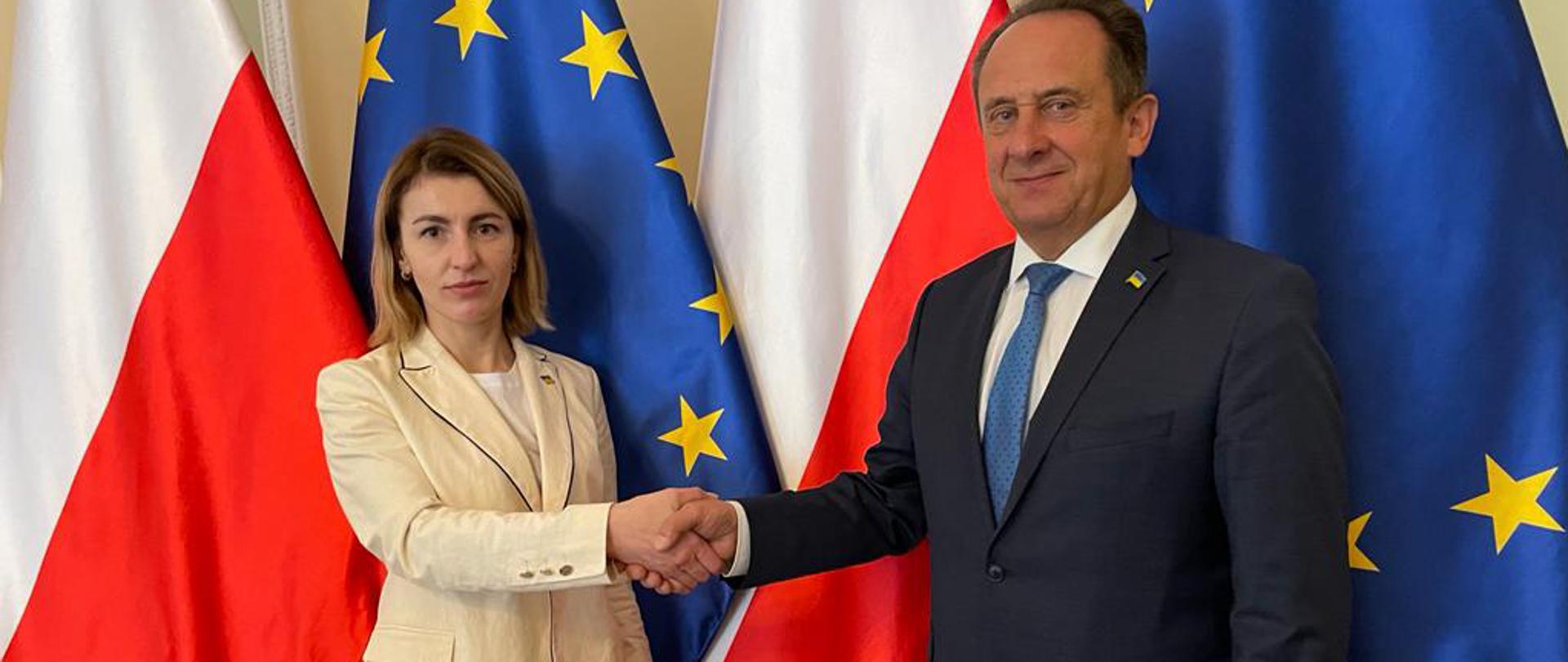 W piątek 29 kwietnia Sekretarz Stanu w Ministerstwie Sportu i Turystyki Andrzej Gut-Mostowy spotkał się z Maryaną Oleskiv, Prezes Państwowej Agencji Rozwoju Turystyki Ukrainy. Na zdjęciu prezes Oleskiv i wiceminister Gut-Mostowy podają sobie dłonie na tle flag Polski i Unii Europejskiej.