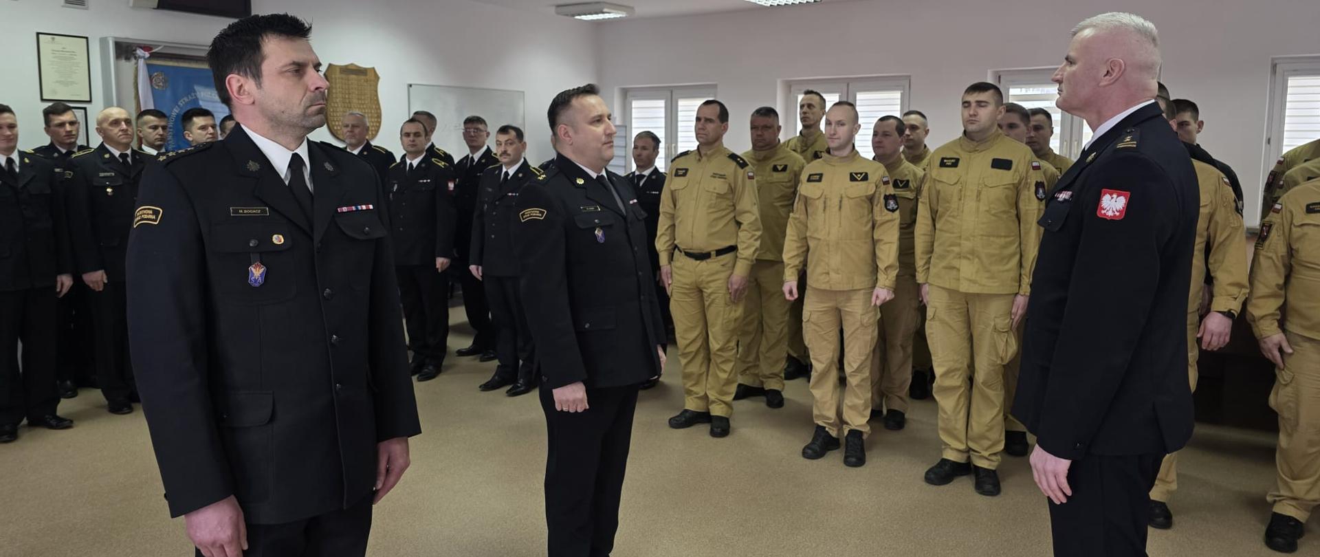 Strażacy przyjmują gratulacje od przełożonego