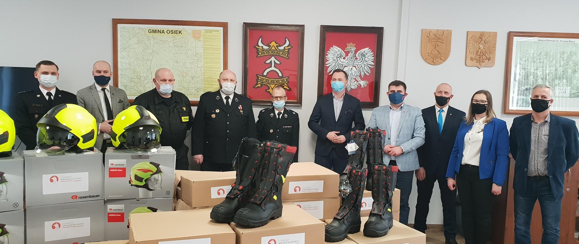 Zdjęcie przedstawia zaproszonych gości podczas uroczystego przekazania sprzętu ochrony osobistej dla strażaków OSP Osiek.