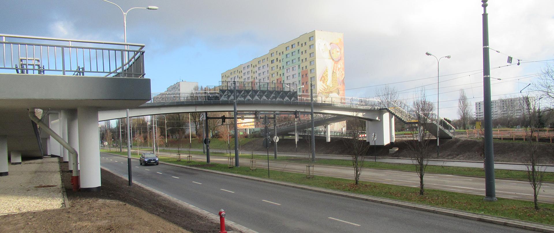 Kładka dla pieszych i rowerzystów nad ruchliwą ulicą na łódzkiej Retkini - widok konstrukcji, schodów oraz podjazdów dla osób z wózkami i rowerów. 