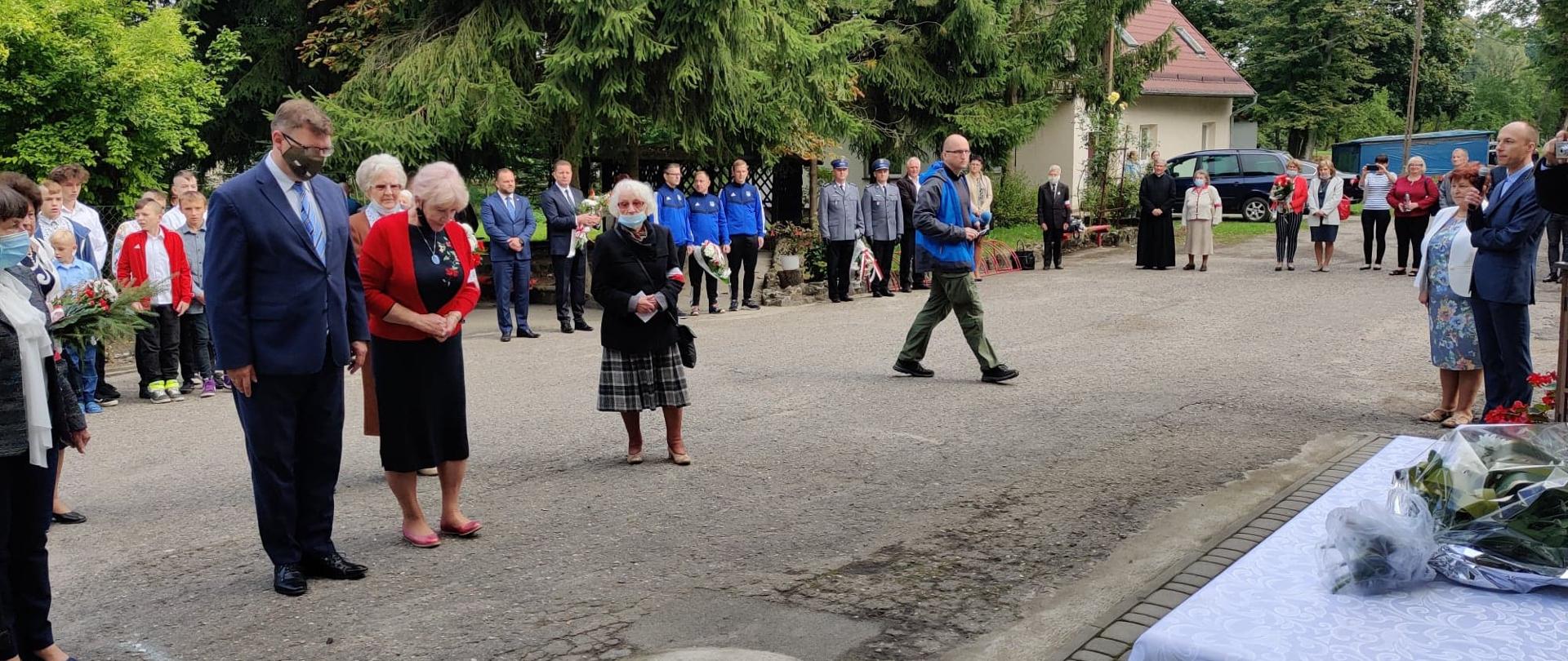 Wojewoda składa kwiaty pod tablicą