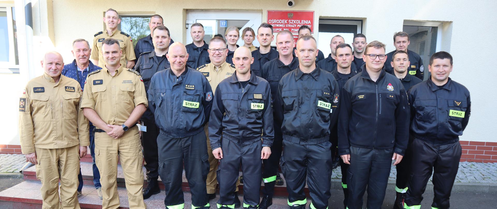 Uczestnicy odprawy koordynatorów ratownictwa medycznego pozują do zdjęcia przed budynkiem Ośrodka Szkolenia KW PSP w Gdańsku z siedzibą w Słupsku.
