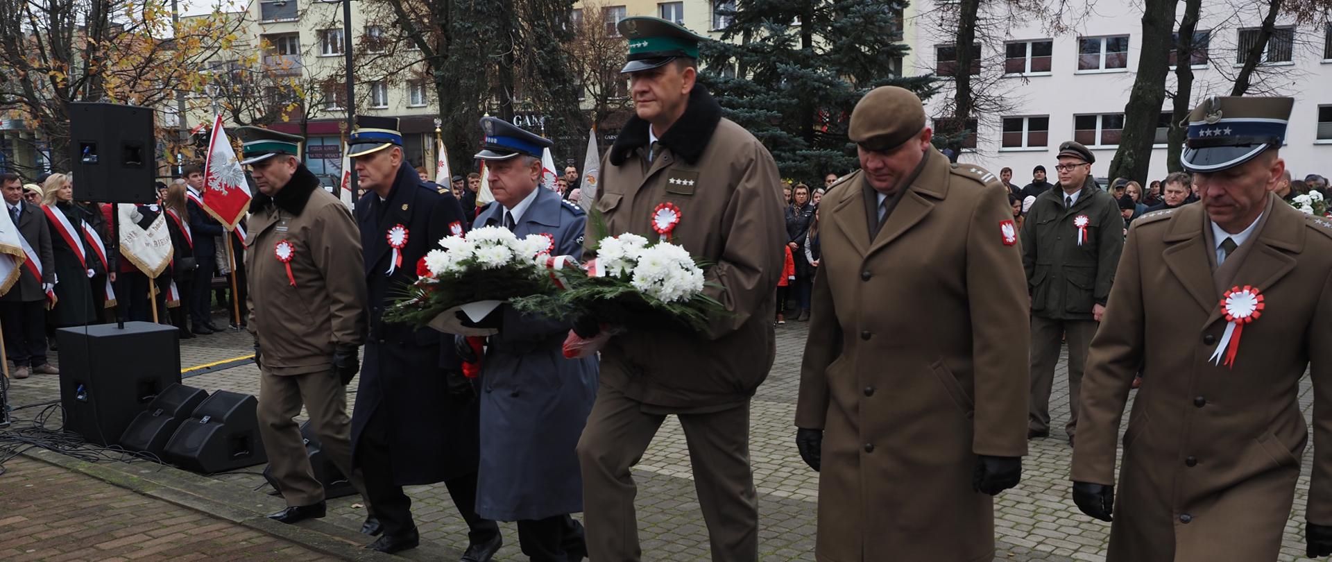 Przedstawiciele służb mundurowych podczas składania kwiatów pod Pomnikiem Niepodległości w Bielsku Podlaskim podczas powiatowych obchodów Narodowego Święta Niepodległości. Wśród delegacji, Komendant Powiatowy PSP w Bielsku Podlaskim mł.bryg. Wojciech Kusznerko.