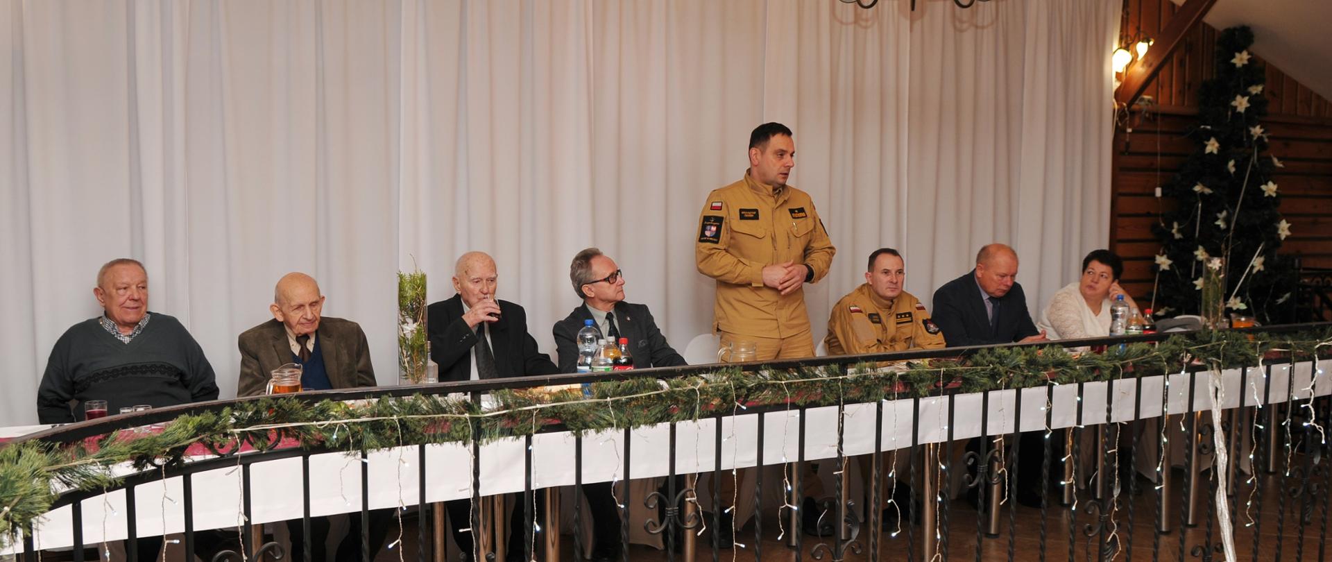 Zdjęcie przedstawia zaproszonych gości organizatorów spotkania. Głos zabiera Świętokrzyski Komendant Wojewódzki nadbryg. Krzysztof Ciosek