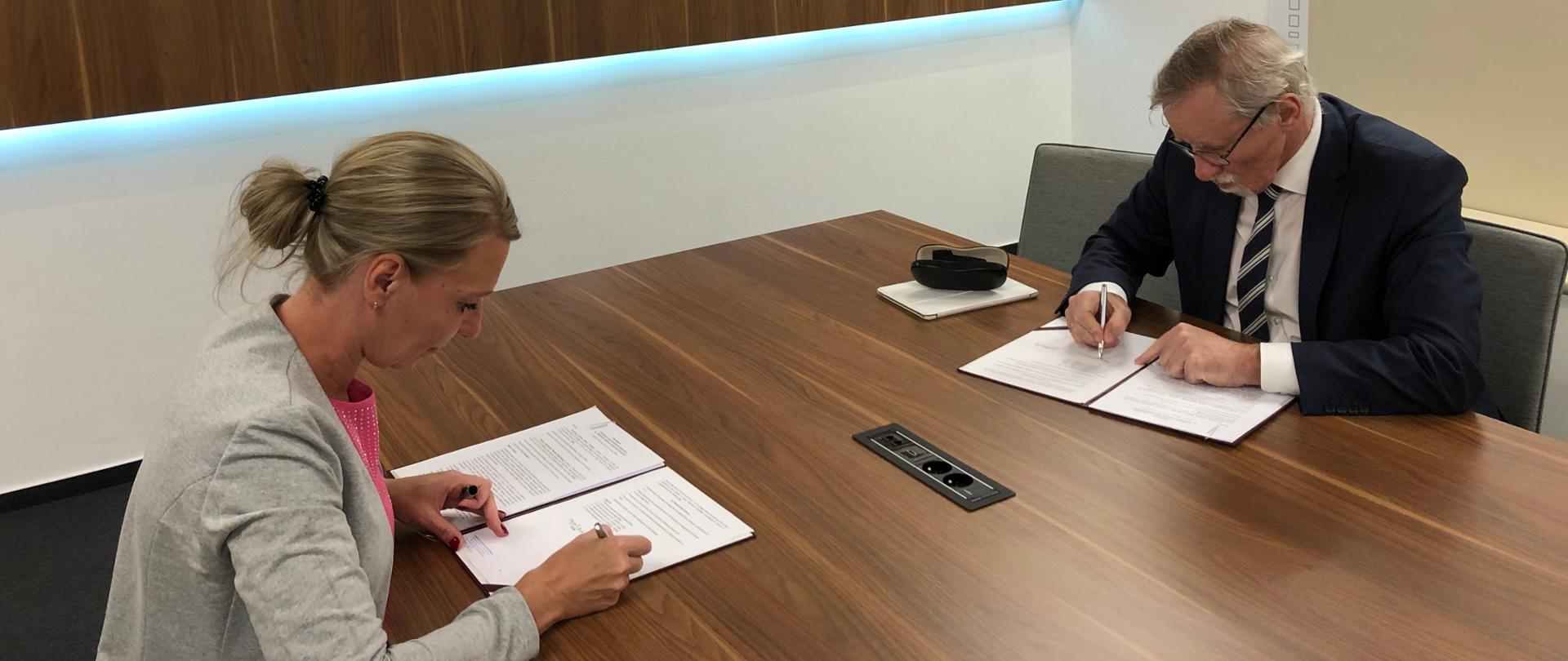 na zdjęciu podpisanie umowy w siedzibie NCBR. od prawej dr inż. Wojciech Kamieniecki i p.o. Głównego Inspektora Nadzoru Budowlanego, Dorota Cabańska