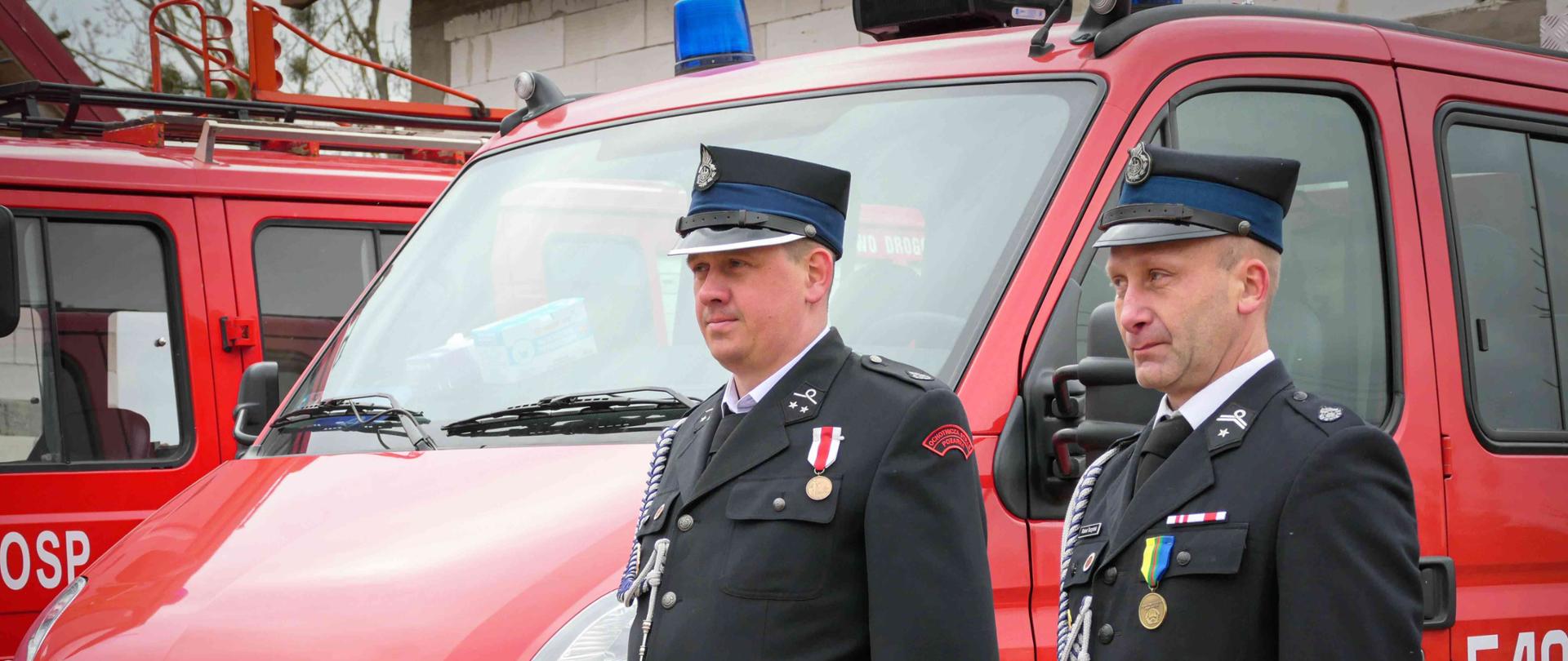 Strażacy stojący przy samochodzie