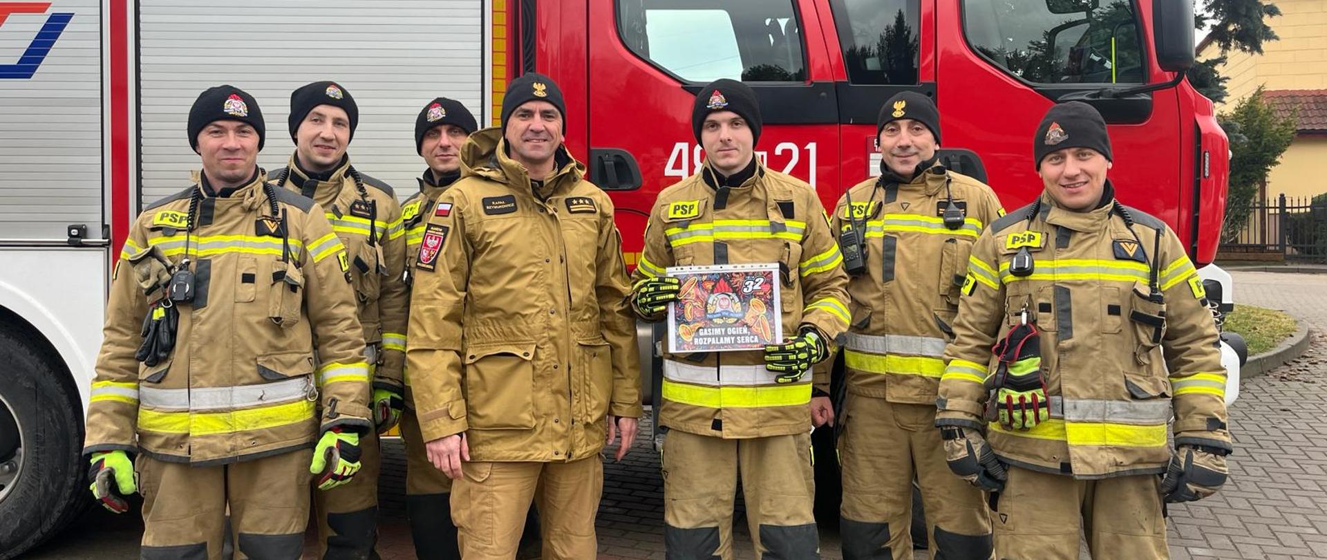 Zdjęcie przedstawia strażaków wraz z Komendantem Powiatowym PSP st.bryg. R.Szymukowiczem