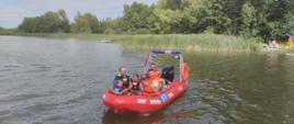 Łódź motorowa na której znajdują się uczestnicy pikniku wraz ze strażakiem 