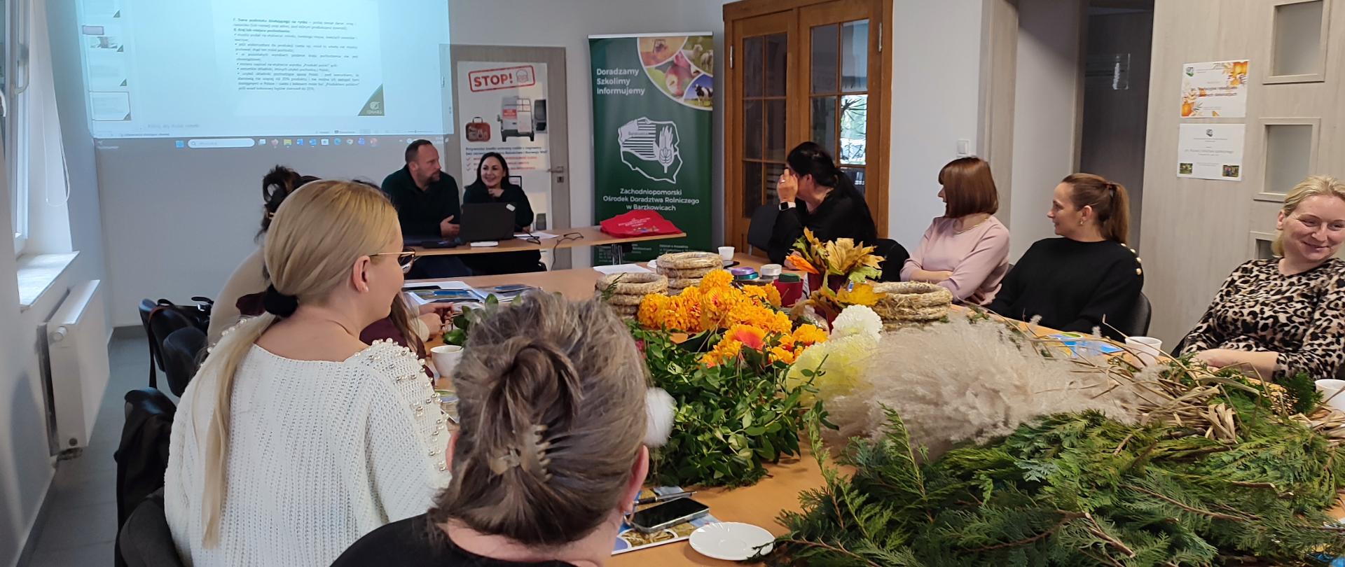 Inspektorzy IJHARS w sali szkoleniowej, w tle prezentacja, w sali liczne grono słuchaczy