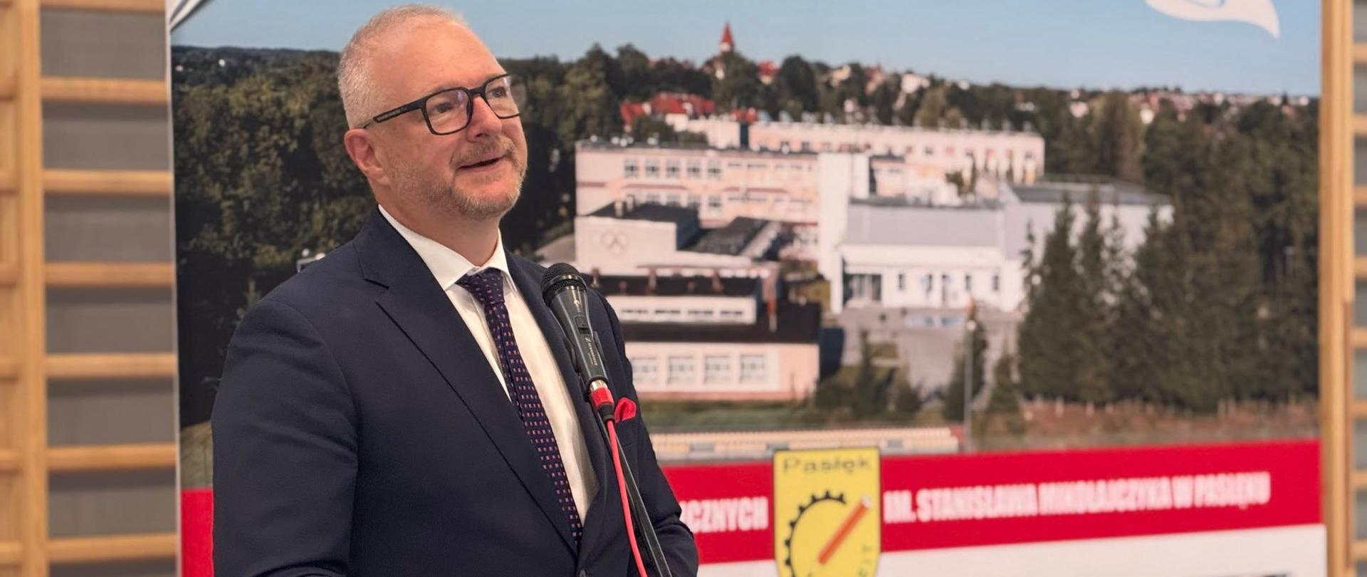 Mężczyzna stoi przy mównicy i wygłasza przemówienie 