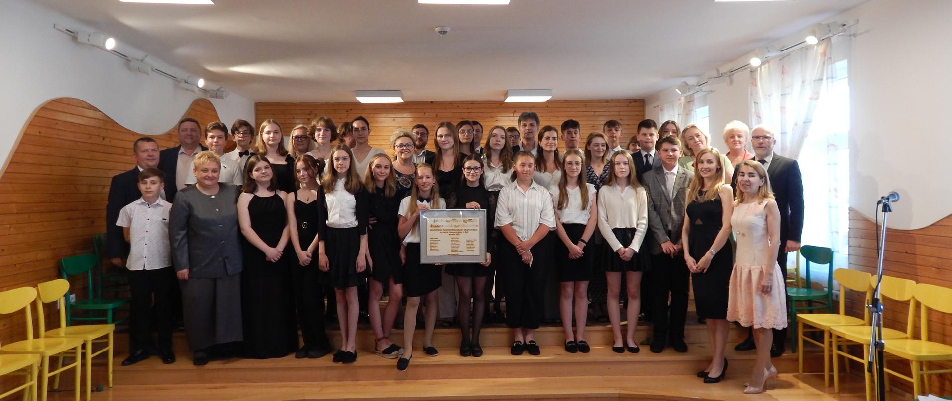 wspólne zdjęcie uczniów kończących szkołę i nauczycieli