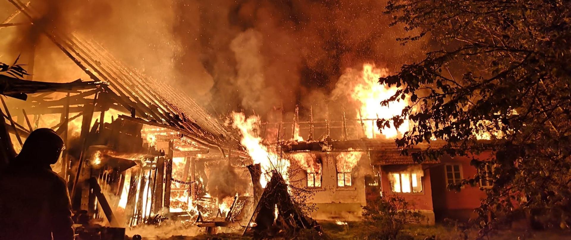 zdjęcie przedstawia płonący cały budynek mieszkalny wraz z budynkiem gospodarczym