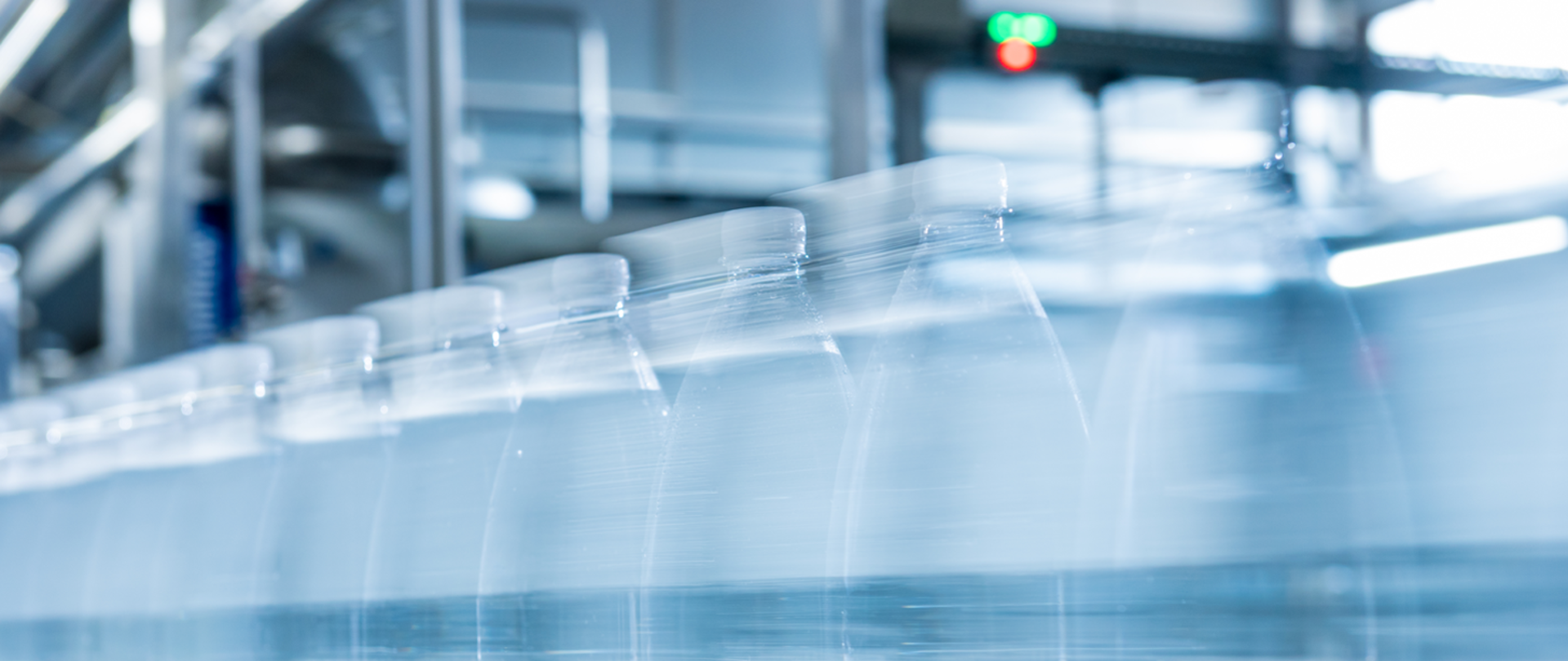 zdjęcie przedstawia butelki wody mineralnej jadące na taśmie produkcyjnej