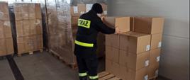 Na zdjęciu strażak podczas przeładunku maseczek do garażu JRG w Przemyślu