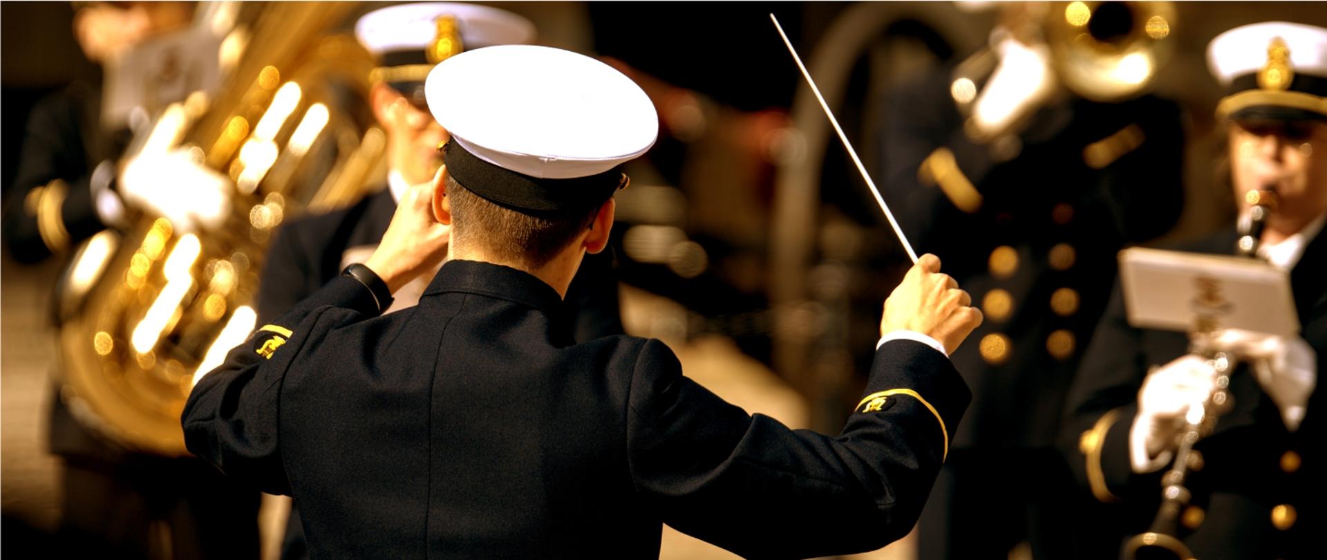 Zdjęcie przedstawia dyrygenta prowadzącego Orkiestrę Wojskową