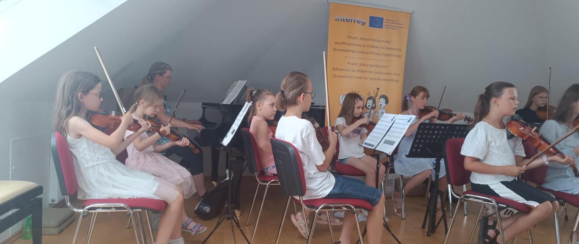 Kultura buduje mosty - grupa dzieci gra na instrumentach smyczkowych