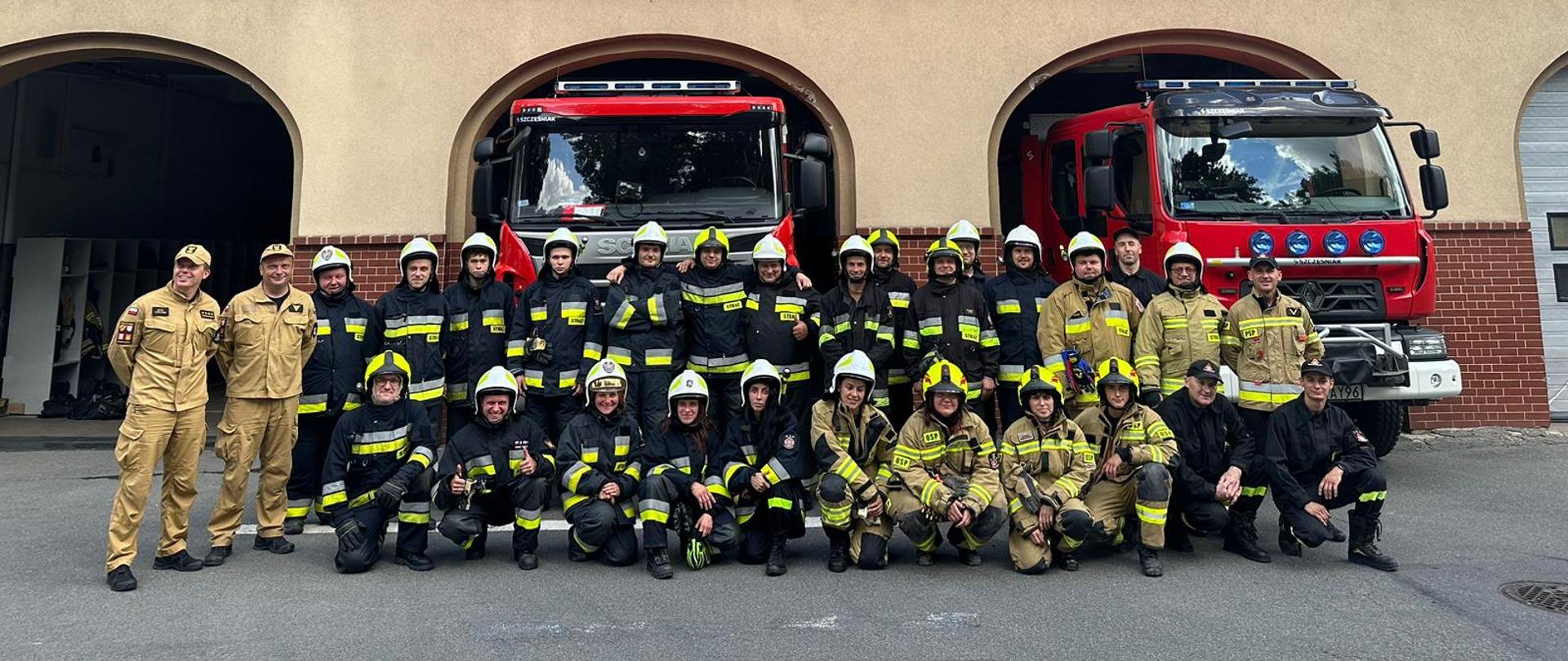 Zdjęcie grupowe druhów Ochotniczych Straży Pożarnych wraz ze strażakami przed budynkiem Komendy. 