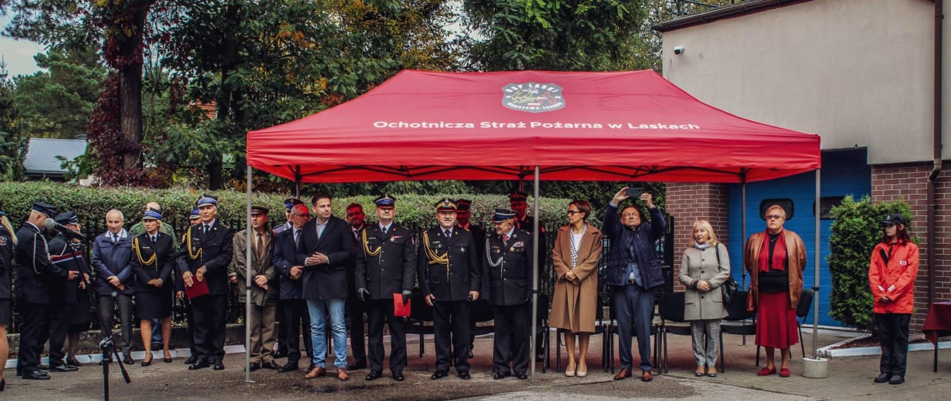 Goście zgormadzeni pod namiotem podczas uroczystości